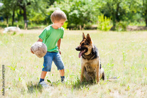 Little boy playing with dog © Rakursstudio