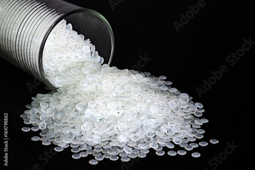 Industrial white plastic beads, granules on black background. photo