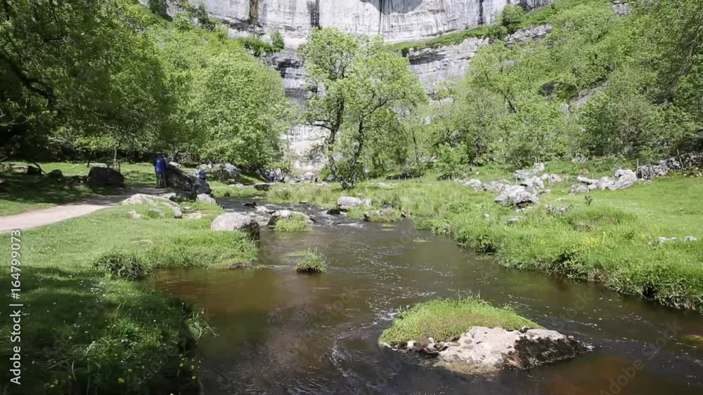 Malham Cove stream at the bottom of the rocks Yorkshire Dales National Park UK popular visitor attraction Malham Cove stream at the bottom of the rocks Yorkshire Dales National Park UK popular visitor attraction