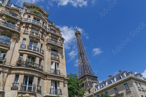 Eiffel tower behind buildings in Paris