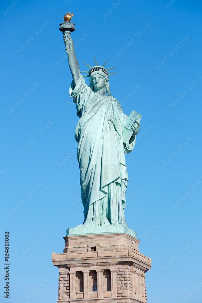 Statue of Liberty with pedestal in a sunny day, blue sky in New York