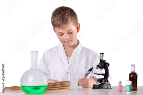Scientist boy in the chemistry lab write with a pen
