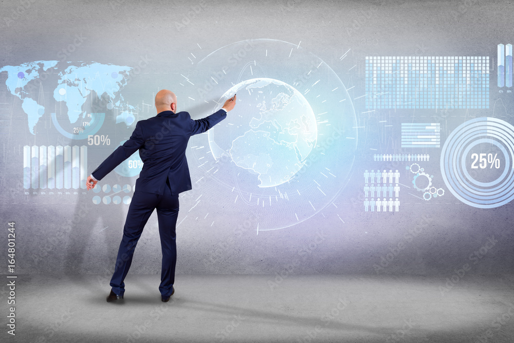 Businessman in front of a wall writing on a technology business futuristic interface - business concept Businessman in front of a wall writing on a technology business futuristic interface - business concept