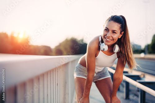 Fototapeta Naklejka Na Ścianę i Meble -  Portrait of woman taking break from jogging