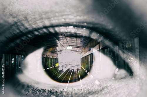 Double exposure of the female eye and tunnel with train car in subway photo