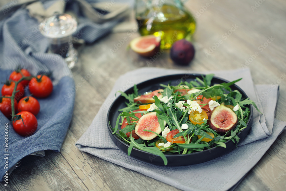 Fresh salad with arugula tomato and cheese on wooden background Fresh salad with arugula tomato and cheese on wooden background