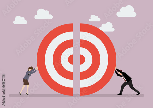 Businessman and woman pushing a pieces of big target together