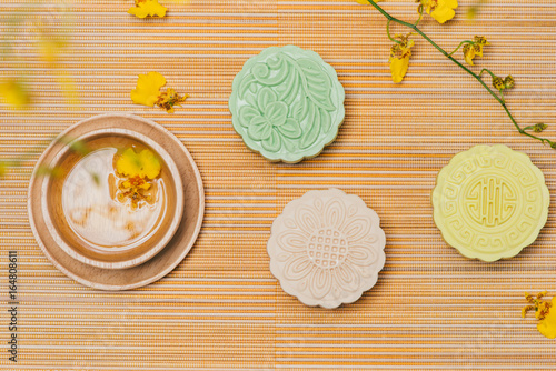 Sweet color of snow skin mooncake. Traditional mid autumn festival foods with tea on table setting.