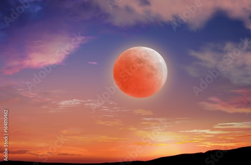 Red sunset and moon . Glowing sunset and full moon  . Dramatic nature background .Religion background . The moon against the background of a romantic decline in clouds
