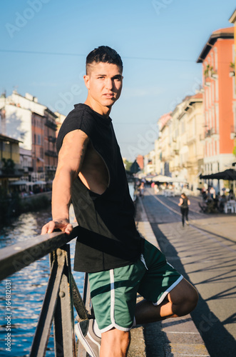 Young handsome man (20-25) chilling out at Milan's, Italy bohemian naviligi district at sunset