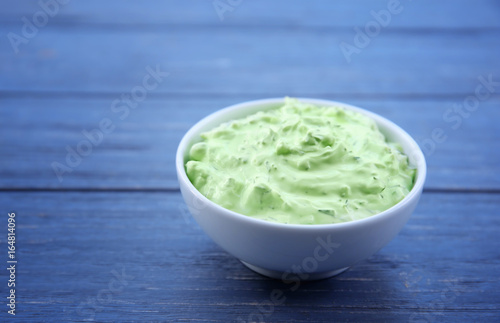 Delicious yogurt sauce in bowl on wooden background