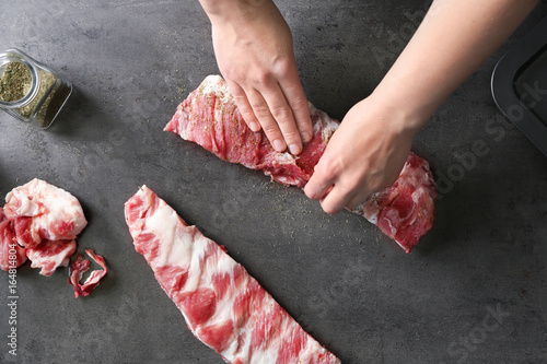 Obraz na plátne Professional cooker spicing fresh juicy spare ribs on table