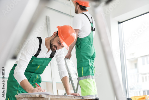 Outgoing master-builder protracting draft in apartment