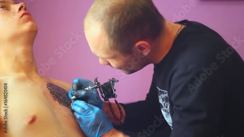 The tattoo artist does the tattoo photo