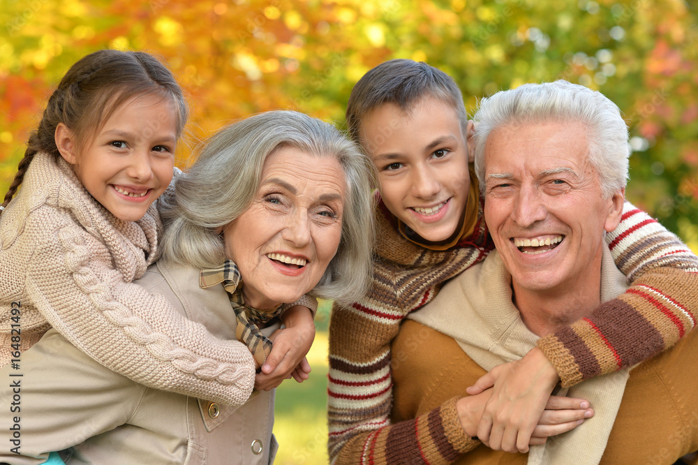  grandfather, grandmother  and grandchildren in park 