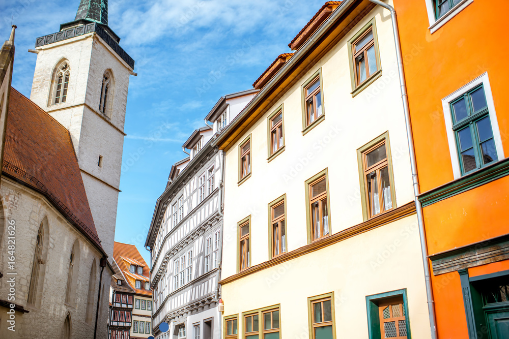 Beautiful street view with colorful buildings and church tower in the old town of Erfurt city during the morning light in Germany