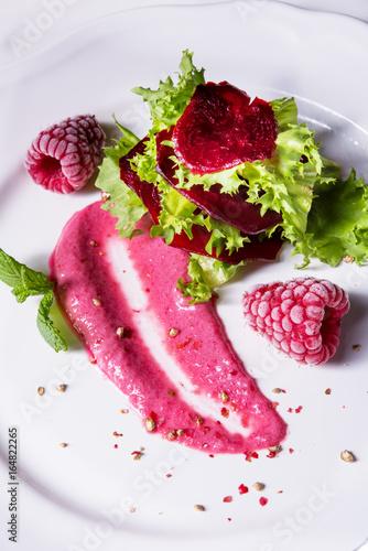 Carpaccio of baked red pray with green salad and raspberry photo