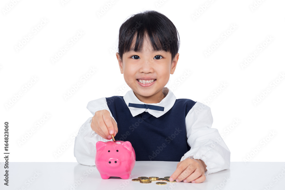 Asian Chinese little girl putting coins into piggy bank Asian Chinese little girl putting coins into piggy bank