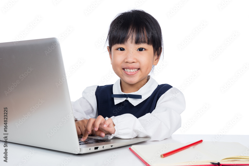 Asian Chinese little girl in uniform studying with laptop Asian Chinese little girl in uniform studying with laptop