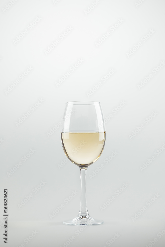 close-up view of wineglass full of white wine isolated on white