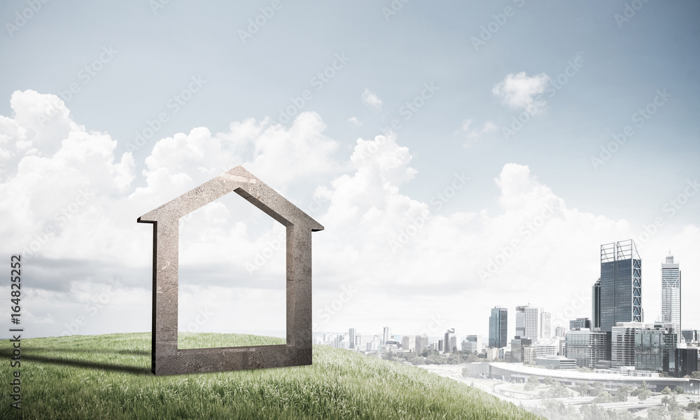 Conceptual image of concrete home sign on hill and natural lands