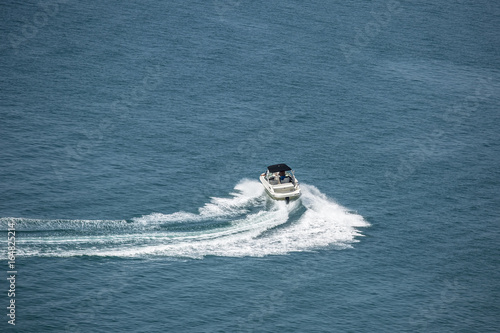 high speed motor boat with wave trail on the water.