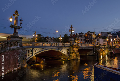 Photography Blauwbrug Blue Bridge over Amstel river in Amsterdam at summer evening, Holland, Netherlands