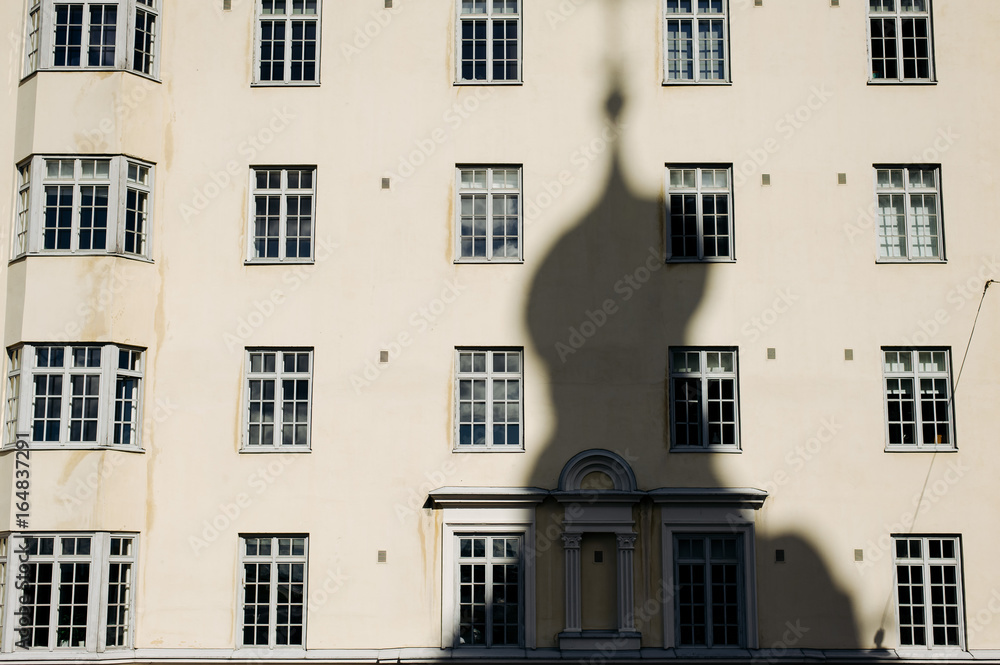 the shadow of the Church on the background of houses with Windows