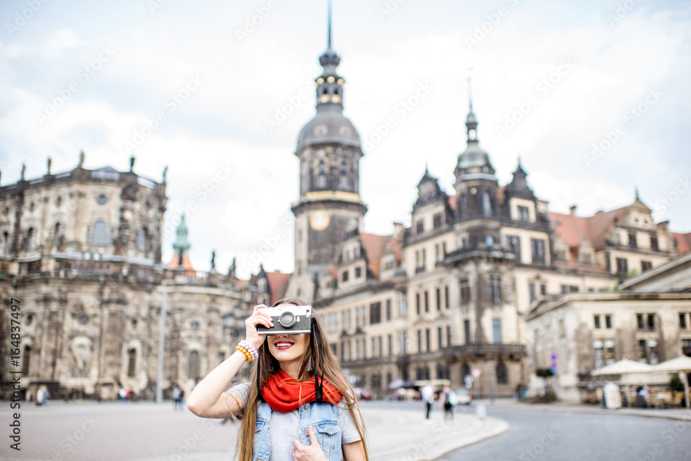 Young woman with photocamera walking on the Theaterplatz in Dresden, Germany