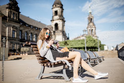 Young woman tourist sitting on the bench on the Bruhl terrace in Dresden, Germany