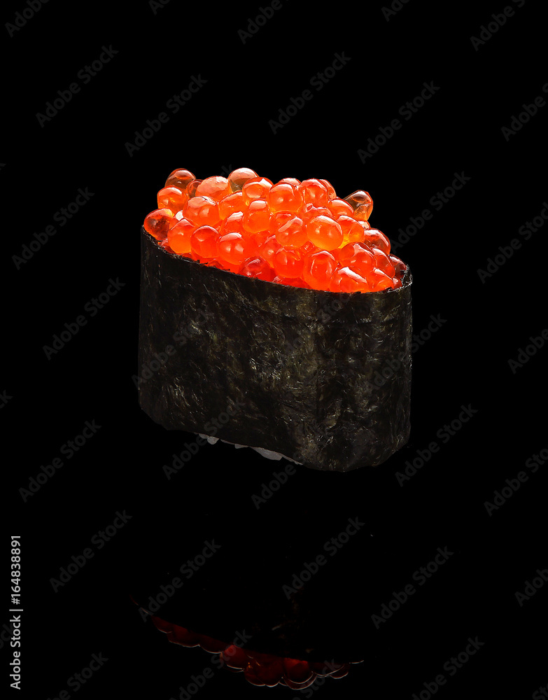 Japanese cuisine. Sushi gunkan with red caviar over black background. Japanese cuisine. Sushi gunkan with red caviar over black background.