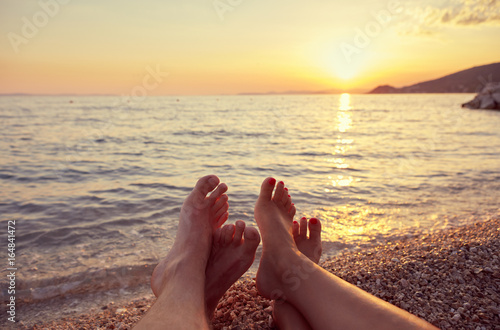 Fototapeta Naklejka Na Ścianę i Meble -  Couple lying on the beach at sunset