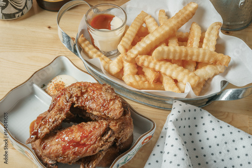 Deep fried chicken wing and french fries