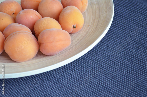 Apricots on a wooden platter. 