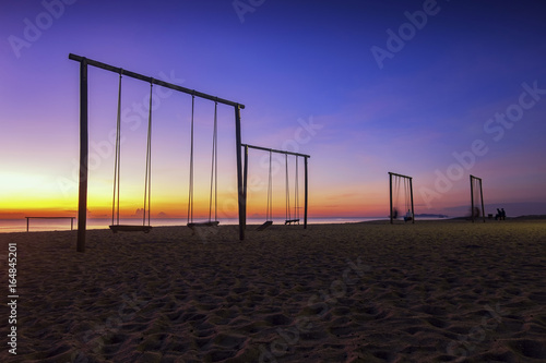 swing and beautiful tropical beach over magical twilight sunrise at dawn