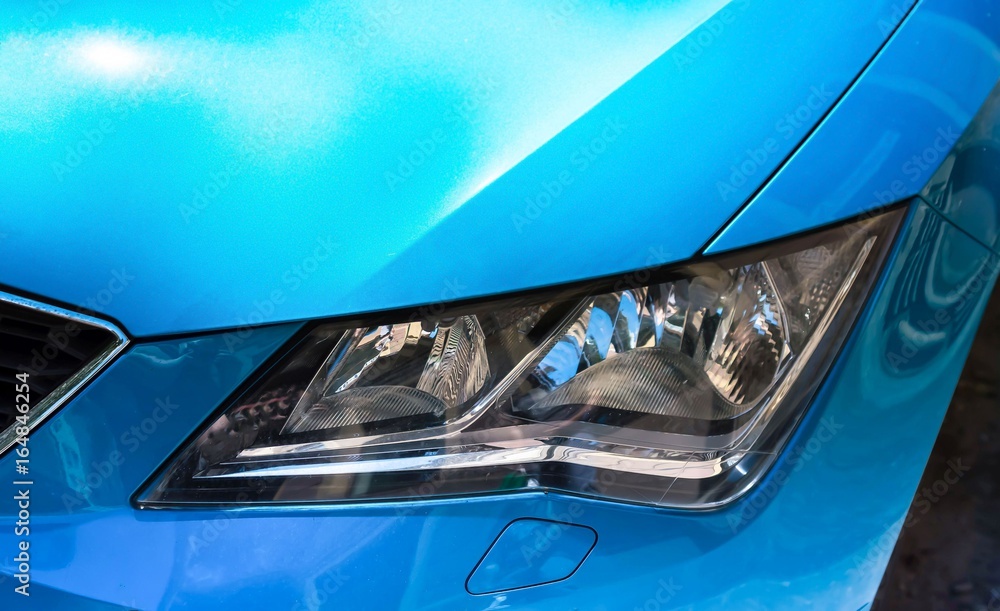 Part of blue car headlight close up