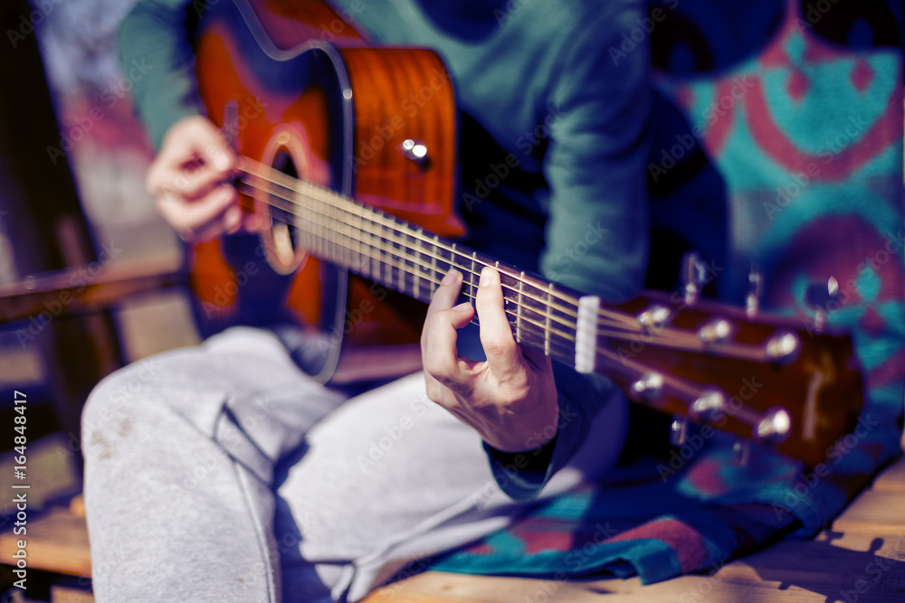 Closeup of man playing an acoustic guitar