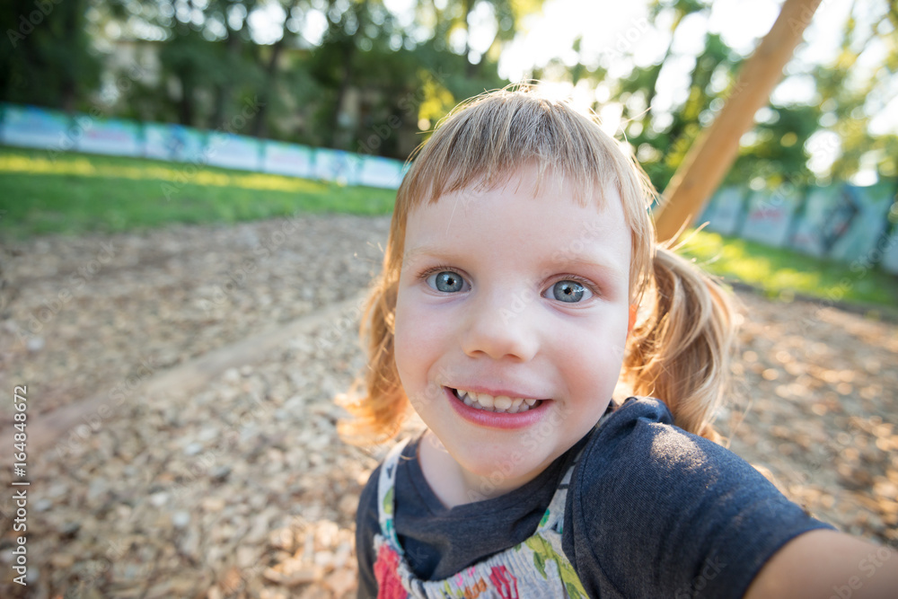 Funny little girl taking selfie in the park Funny little girl taking selfie in the park