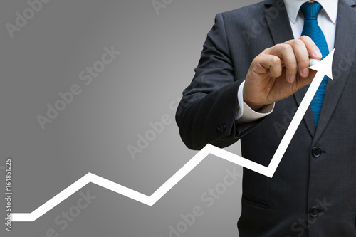 businessman drawing the financial line charts showing growing revenue on touch screen