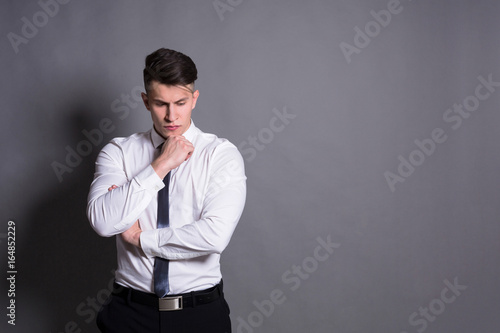 Pensive businessman at gray studio background