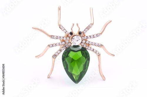 Golden spider with a big green stone isolated on white