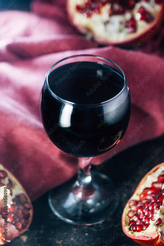 Fresh pomegranate juice in glass over black background. Fresh pomegranate juice in glass over black background.