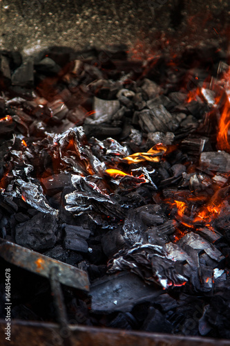 Embers. Ash in the barbecue grill and shovel for stirring the coals.