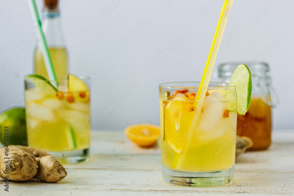 Fototapeta premium Fresh Ginger lemonade over white wooden background