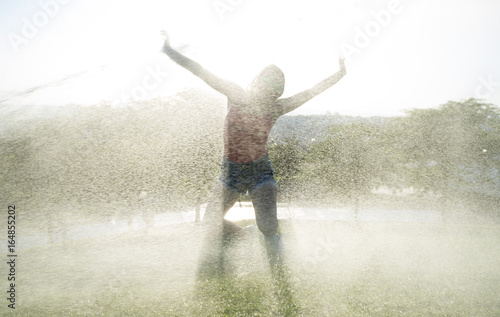 Schilderij op canvas Pretty girl gets wet with water in a park