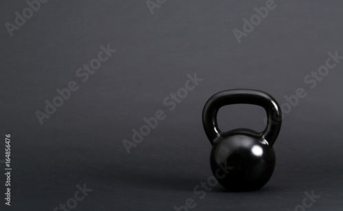 Fototapeta Naklejka Na Ścianę i Meble -  Black cast iron kettlebell on a black background
