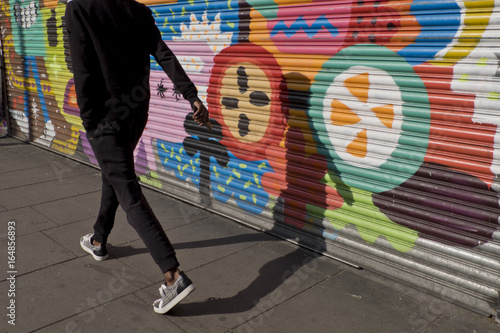 Photography Man casting a shade in a colourful wall in Brixton,London,UK