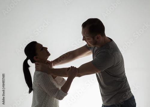 couple having fight and man choking woman photo