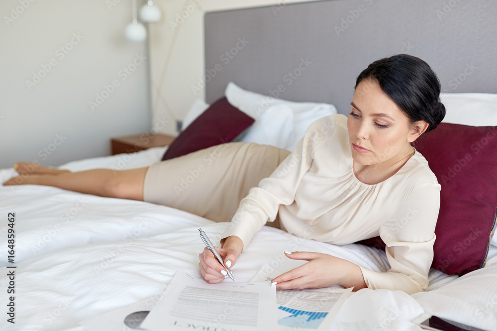 businesswoman with papers working at hotel room businesswoman with papers working at hotel room