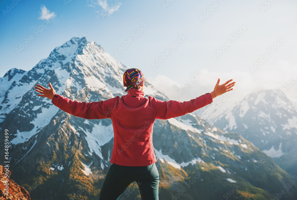 Woman hiker standing on the top of mountain. Back pose Woman hiker standing on the top of mountain. Back pose
